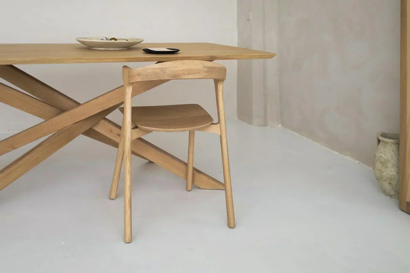 Mesa de madera maciza en comedor moderno con luz natural